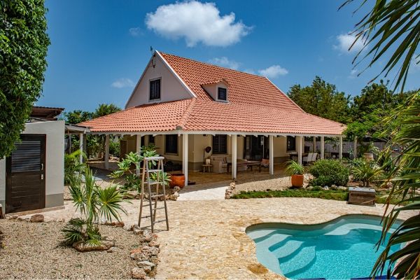Sfeervol Bonairiaans huis te koop met gastenverblijf in de rustige wijk Finca Verde. Samen 4 slaapkamers, 3 badkamers, een zwembad en een mooie buitenkeuken! Deze woning is VERKOCHT.